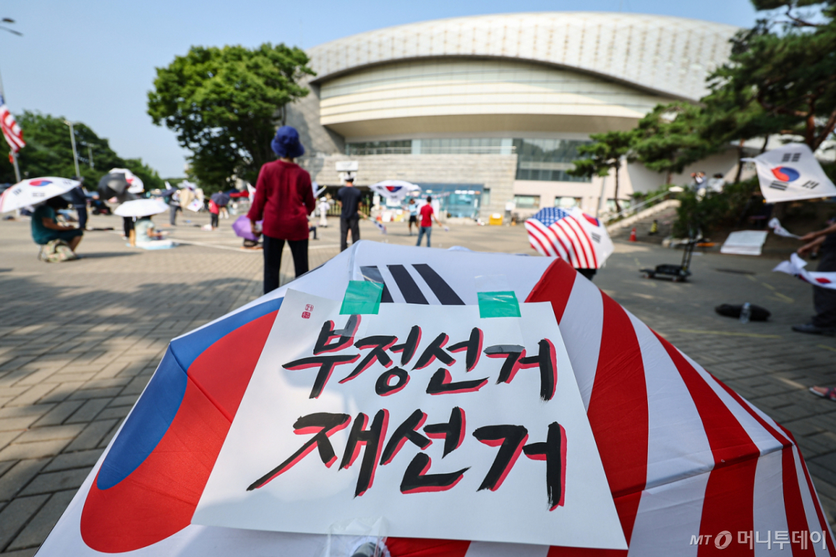 (서울=뉴스1) 김도우 기자 = 6·3 지방선거 투표용지 부족사태로 인한 '잠실 봉쇄시위'가 26일째를 맞은 30일 서울 송파구 올림픽공원 핸드볼경기장 인근에서 참가자들이 재선거를 요구하는 구호를 외치고 있다. 2026.6.30/뉴스1 Copyright © 뉴스1. All rights reserved. 무단 전재 및 재배포, AI학습 이용 금지. /사진=(서울=뉴스1) 김도우 기자