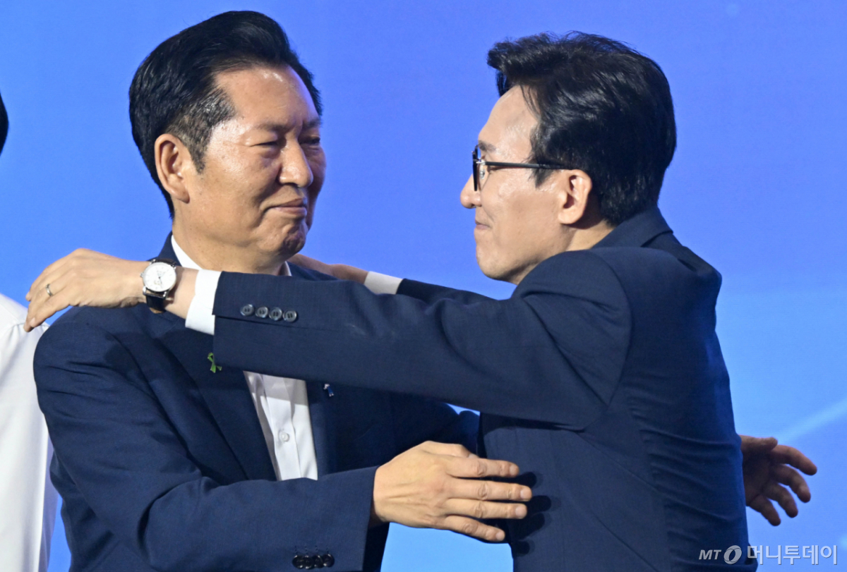 (대전=뉴스1) 황기선 기자 = 김민석 더불어민주당 신임 당대표가 17일 대전시 유성구 대전컨벤션센터에서 열린 더불어민주당 제3차 정기전국당원대회에서 정청래 후보와 포옹하고 있다. (공동취재) 2026.8.17/뉴스1 Copyright © 뉴스1. All rights reserved. 무단 전재 및 재배포, AI학습 이용 금지. /사진=(대전=뉴스1) 황기선 기자