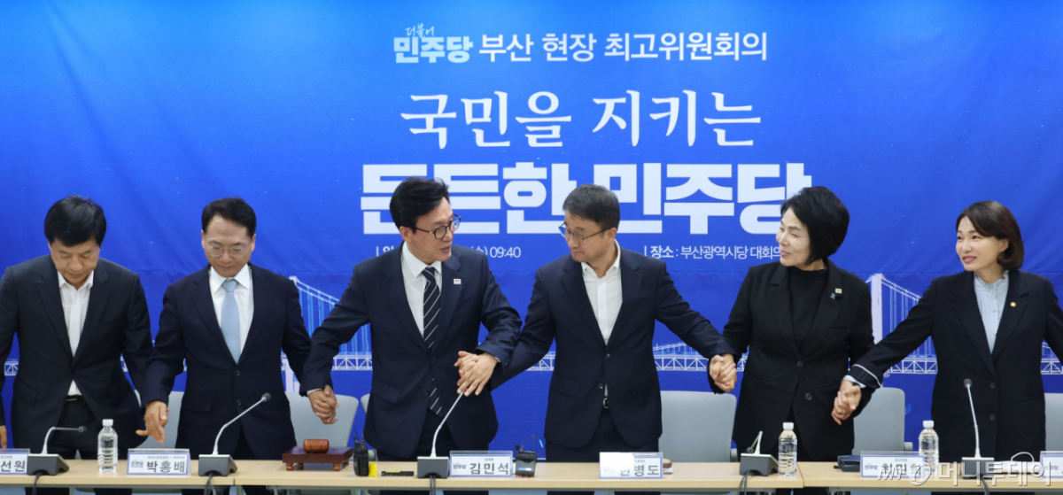 (부산=뉴스1) 신웅수 기자 = 김민석 더불어민주당 대표가 19일 부산 동구 민주당 부산시당에서 열린 현장 최고위원회의에서 한병도 원내대표, 최고위원들의 손을 잡고 있다. 2026.8.19/뉴스1 Copyright © 뉴스1. All rights reserved. 무단 전재 및 재배포, AI학습 이용 금지. /사진=(부산=뉴스1) 신웅수 기자