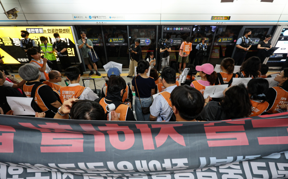 전국장애인차별철폐연대(전장연) 활동가들이 18일 오전 서울 중구 지하철 4호선 서울역에서 '72차 출근길 지하철 탑니다' 시위를 하고 있다. /뉴스1