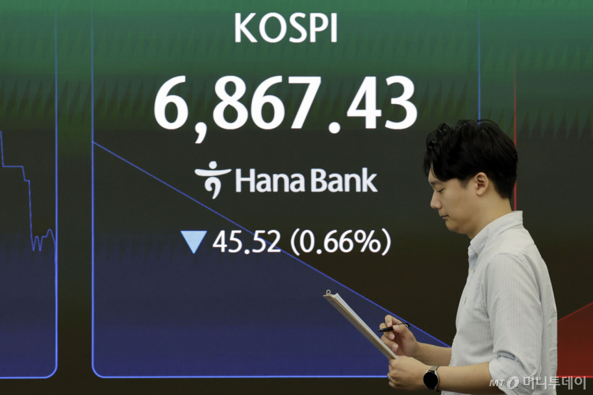 코스피가 전 거래일보다 31.88포인트(0.46%) 하락한 6881.07로 장을 시작한 24일 서울 중구 하나은행 딜링룸에서 딜러들이 업무를 보고 있다. /사진=뉴시스