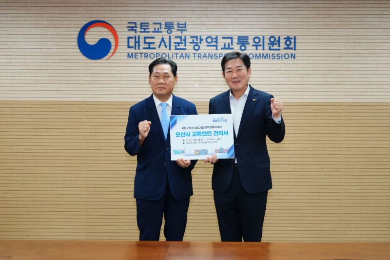 조용호 오산시장(오른쪽)이 25일 김용석 대도시권광역교통위원장에게 광역버스 증차·세교3 광역교통개선 대책 비율 상향 내용을 담은 건의문을 전달하며 기념촬영을 하고 있다./사진제공=오산시