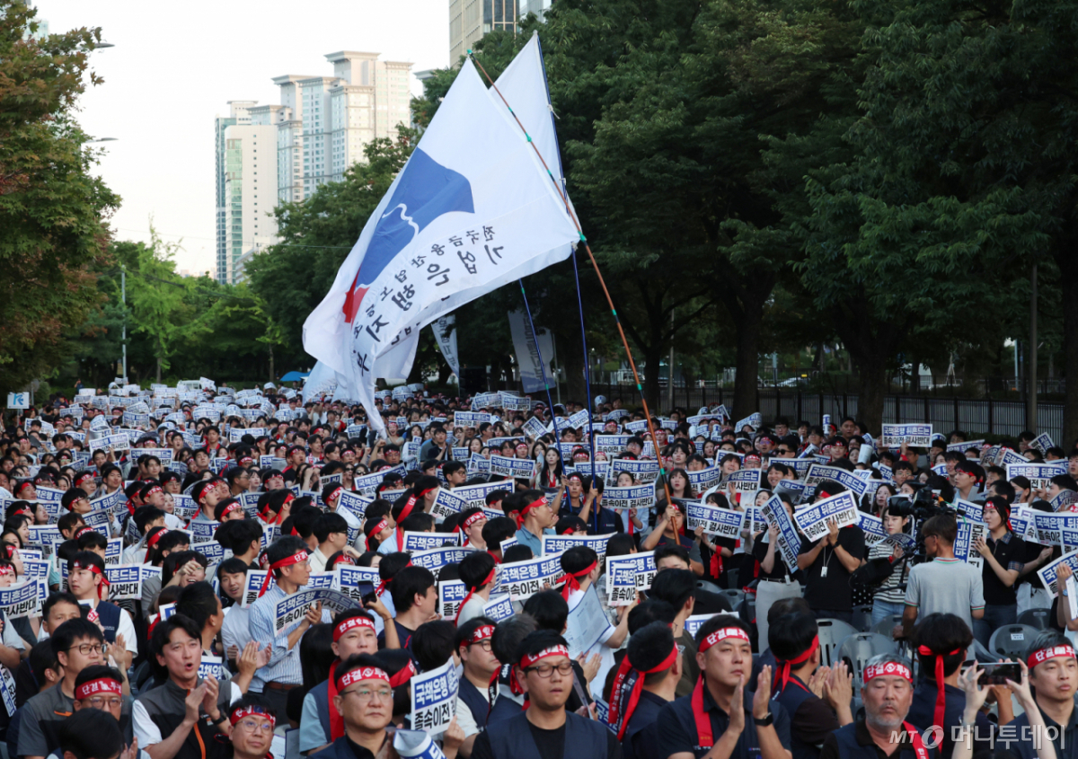 [서울=뉴시스] 이영환 기자 = 11일 오후 서울 여의도 한국산업은행 본점 옆 의사당대로에서 한국산업은행지부, 기업은행지부, 한국수출입은행지부가 주최한 국책은행 지방이전 저지 총력투쟁 결의대회에서 깃발 입장이 진행되고 있다. 2026.08.11. 20hwan@newsis.com /사진=이영환
