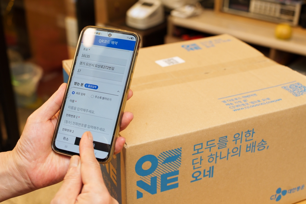 오산 오색시장 상인이 '오네' 앱에서 QR코드를 활용해 택배 배송 접수를 하고 있다. /사진제공=CJ대한통운