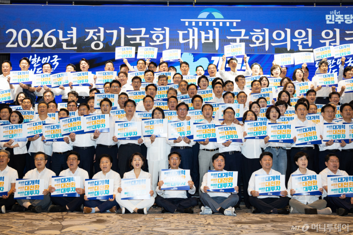  김민석 더불어민주당 대표를 비롯한 의원들이 27일 인천 영종구 인스파이어 엔터테인먼트 리조트에서 열린 2026년 정기국회 대비 국회의원 워크숍에서 손팻말을 들고 구호를 외치고 있다./사진=뉴스1
