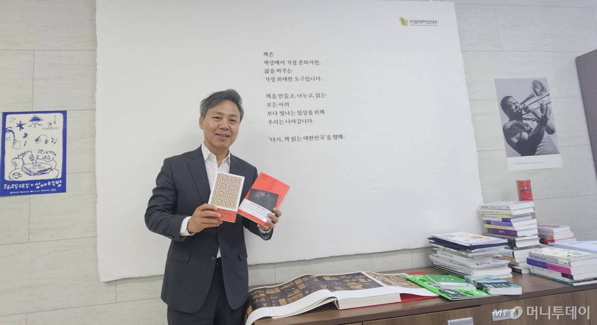 김승수 한국출판문화산업진흥원장이 자신의 집무실에서 즐겨 읽는 책을 들어 보이고 있다. / 사진 = 오진영 기자