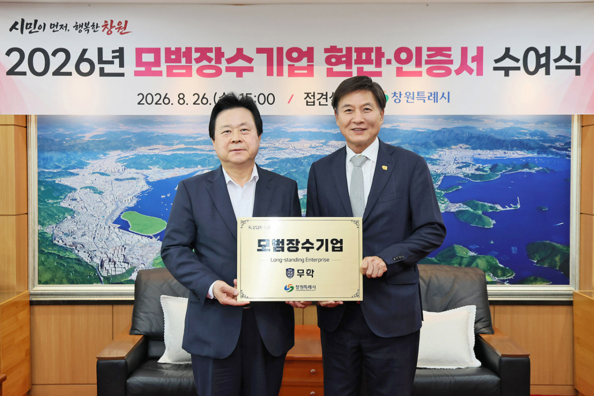 최재호 무학 회장(오른쪽)이 모범장수 기업 인증 현판을 받고 강기윤 창원특례시장과 기념촬영을 하고 있다./사진제공=무학