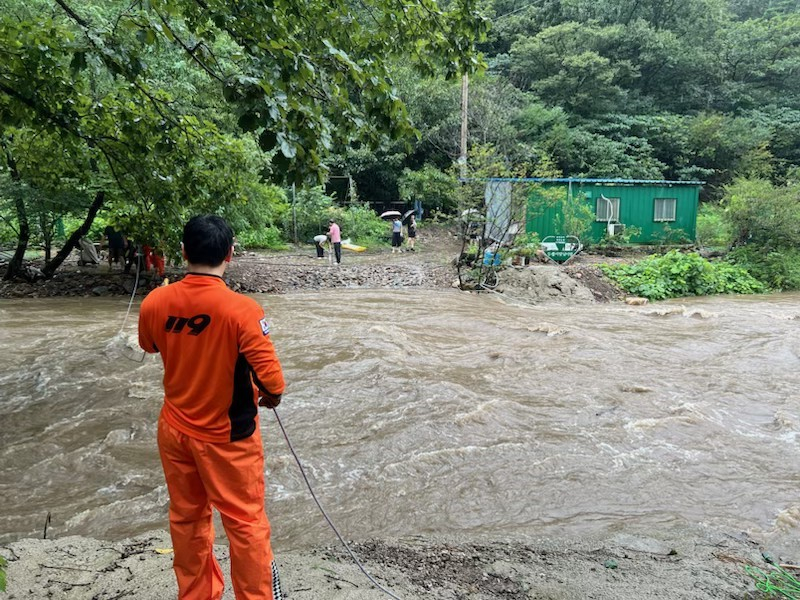 30일 오후 전남광주 화순군 한천면 죽헌로 일대에서 호우로 범람한 계곡물에 도로가 침수되자 소방대원들이 고립된 주민들을 구조하고 있다. /서진제공=전남광주통합소방본부