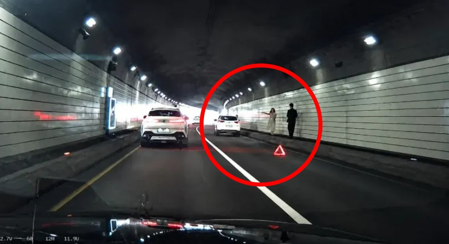 서울 남산3호터널에서 예비부부로 추정되는 남녀가 차로 하나를 막고 웨딩 촬영을 하는 모습(붉은색 원)이 포착돼 논란이다./사진=온라인 SNS 화면 갈무리.