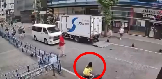 일본 도쿄 최대 번화가 중 한 곳인 신주쿠 가부키초에서 한 여성(붉은 원)이 사람들이 오가는 길거리에서 옷을 내리고 용변을 보는 것으로 추정되는 영상이 확산해 논란이 일고 있다./사진=온라인 SNS 화면 갈무리.
