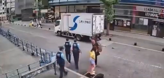 여성이 배수구 부근에 쪼그려 앉아 있는 가운데 경찰관으로 보이는 남성들이 주변을 지나가고 있는 영상 속 장면. /사진=온라인 SNS 화면 갈무리