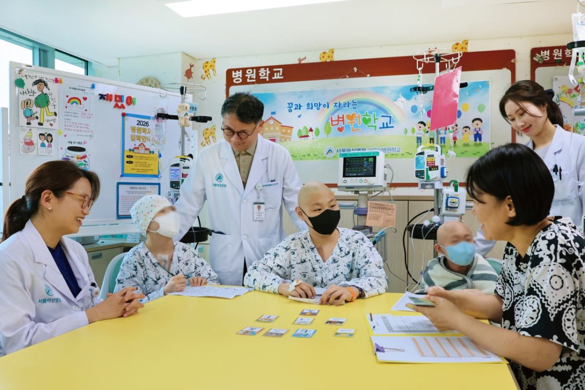 서울아산병원 어린이병원학교에서 김혜리 어린이병원학교장, 임호준 어린이병원장(왼쪽 첫 번째, 세 번째)이 자원봉사자 이은정 교사에게 한문수업을 듣고있는 소아암 환아들을 격려하고 있는 모습. /사진제공=서울아산병원