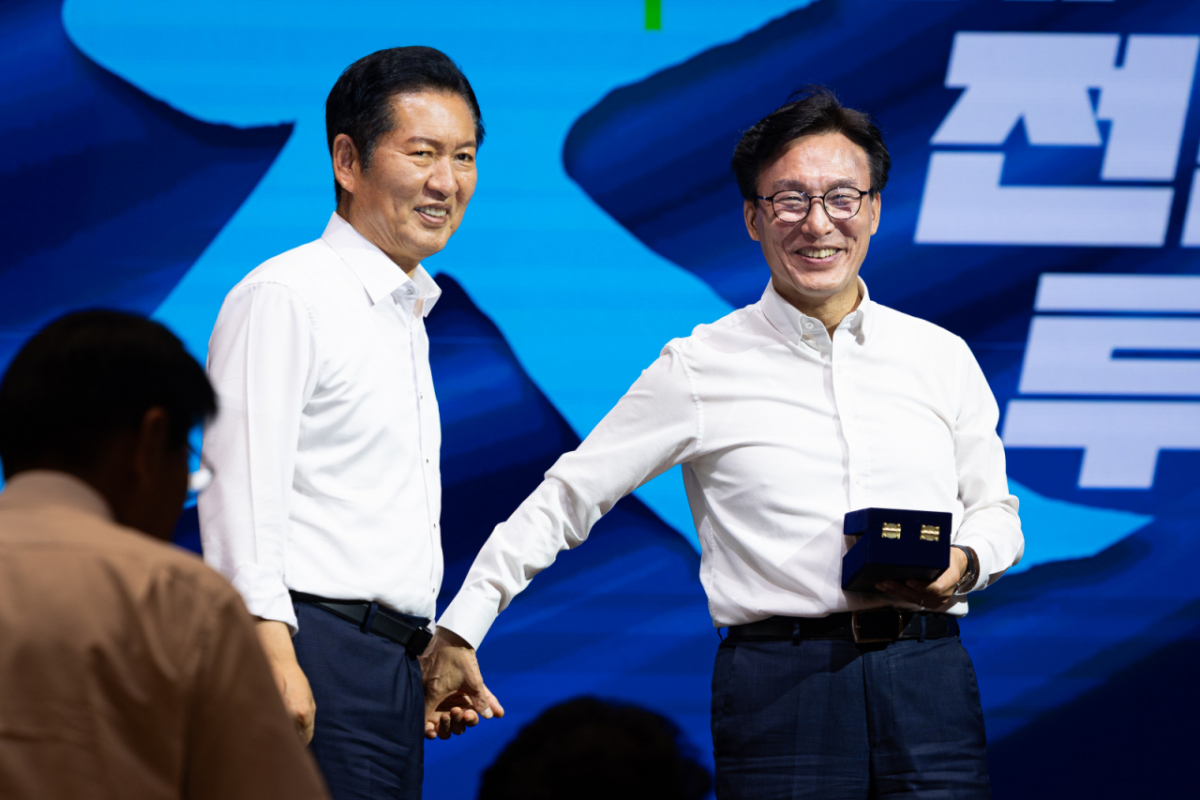 김민석 더불어민주당 대표가 27일 인천 영종구 인스파이어 엔터테인먼트 리조트에서 열린 2026년 정기국회 대비 국회의원 워크숍에서 정청래 전 대표에게 감사패 전달에 앞서 손을 잡고 있다./사진=뉴스1.
