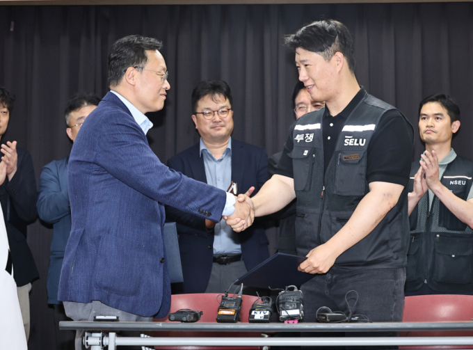 지난 5월20일 경기 수원시 장안구 경기고용노동청에서 열린 삼성전자 임금협상을 마친 후 여명구 삼성전자 DS(디바이스솔루션·반도체 사업 담당) 피플팀장과 최승호 삼성그룹 초기업노동조합 삼성전자지부 위원장이 악수를 하고 있다. /사진제공=뉴스1