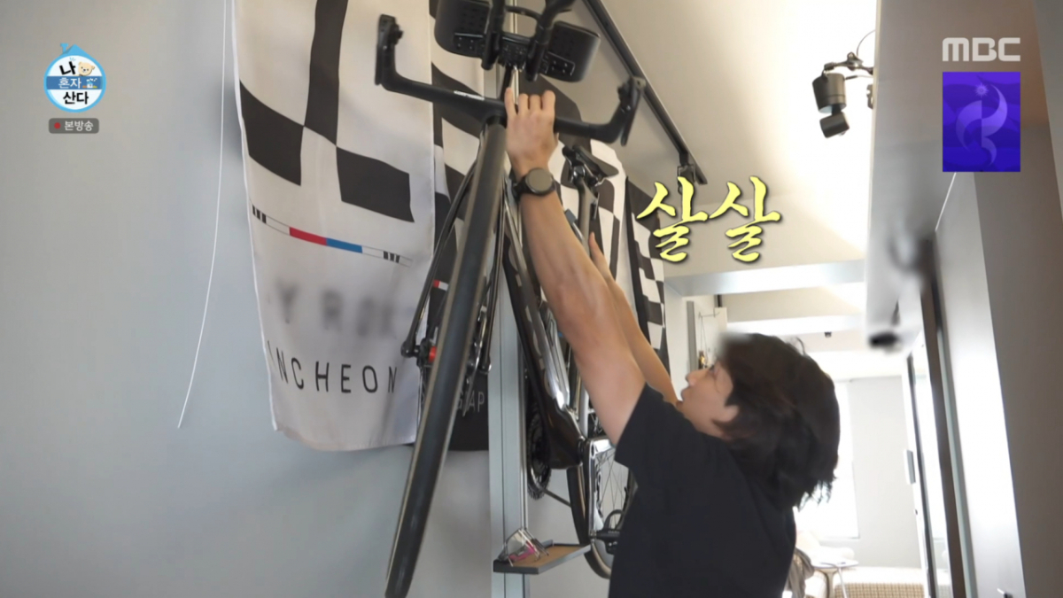 민호가 하이록스 입상 깃발과 철인 3종 자전거를 벽에 걸어 운동광 인테리어를 완성했다. /사진=MBC '나 혼자 산다' 캡처