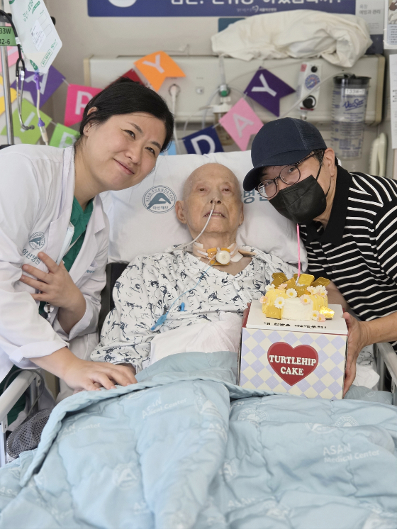 (왼쪽부터)구민정 서울아산병원 심장혈관흉부외과 교수와 이승만 환자·보호자가 수술 후 병실에서 맞은 이씨의 100번째 생일을 축하하며 기념촬영을 하고 있다. /사진제공=서울아산병원