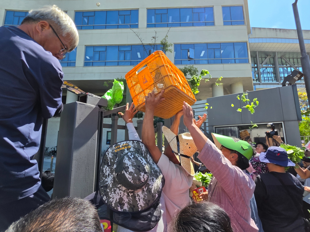 8일 오후 농림축산식품부 앞에서 열린 열린 포괄적·점진적 환태평양경제동반자협정(CPTPP) 가입 추진 반대 집회에서 농민들이 농식품부 청사 안으로 농산물을 던지며 정부의 CPTPP 가입 추진 움직임에 항의하고 있다. /사진=이수현 기자