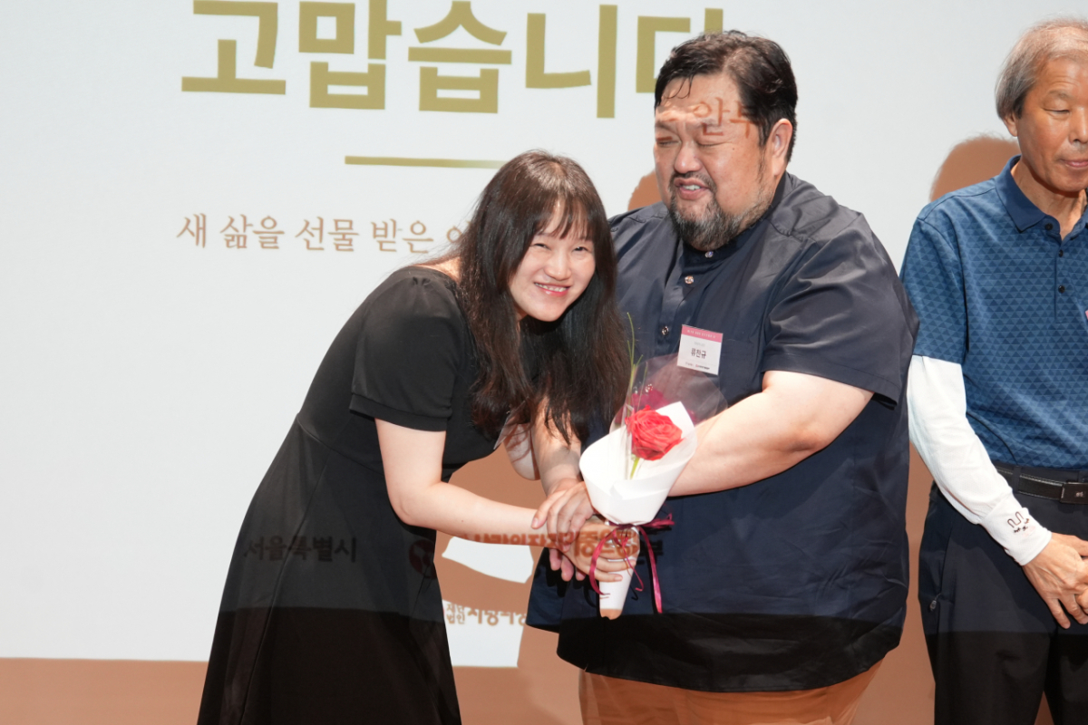 9일 장기기증의 날 기념식에서 각막기증인 유가족 서정민씨(44)에게 장미꽃을 선물하는 각막이식인 류찬규 목사(59)./사진제공=사랑의장기기증운동본부.