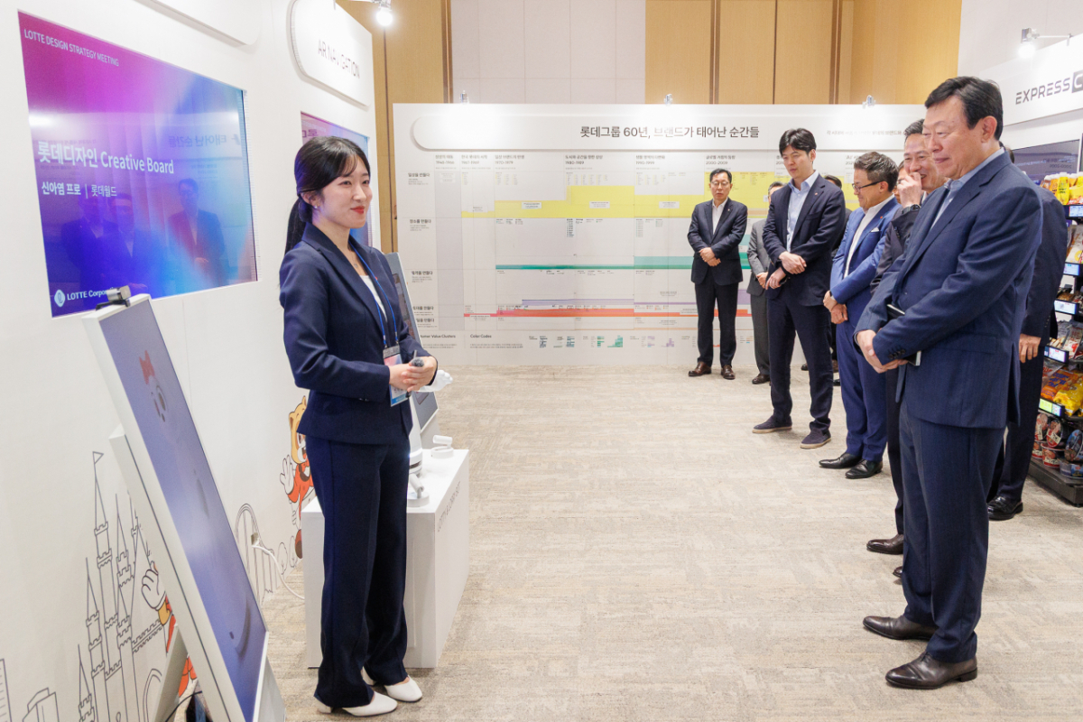 롯데는 10일 롯데월드타워에서 '2026 롯데 디자인전략회의'를 개최했다. 신동빈 롯데 회장(오른쪽 첫번째)이 젊은 디자이너들의 AI 프로젝트 결과물인 '로티로리 로봇 롯데월드 안내 서비스'에 대한 설명을 듣고 있다. /사진제공=롯데지주