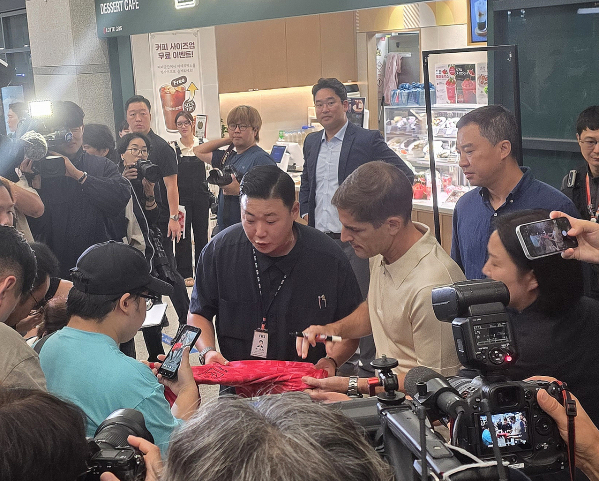 13일 인천국제공항을 통해 입국한 뒤 인터뷰를 마치고 현장을 찾은 팬들에게 사인을 해주고 있는 로베르트 모레노 감독. /사진=김명석 기자