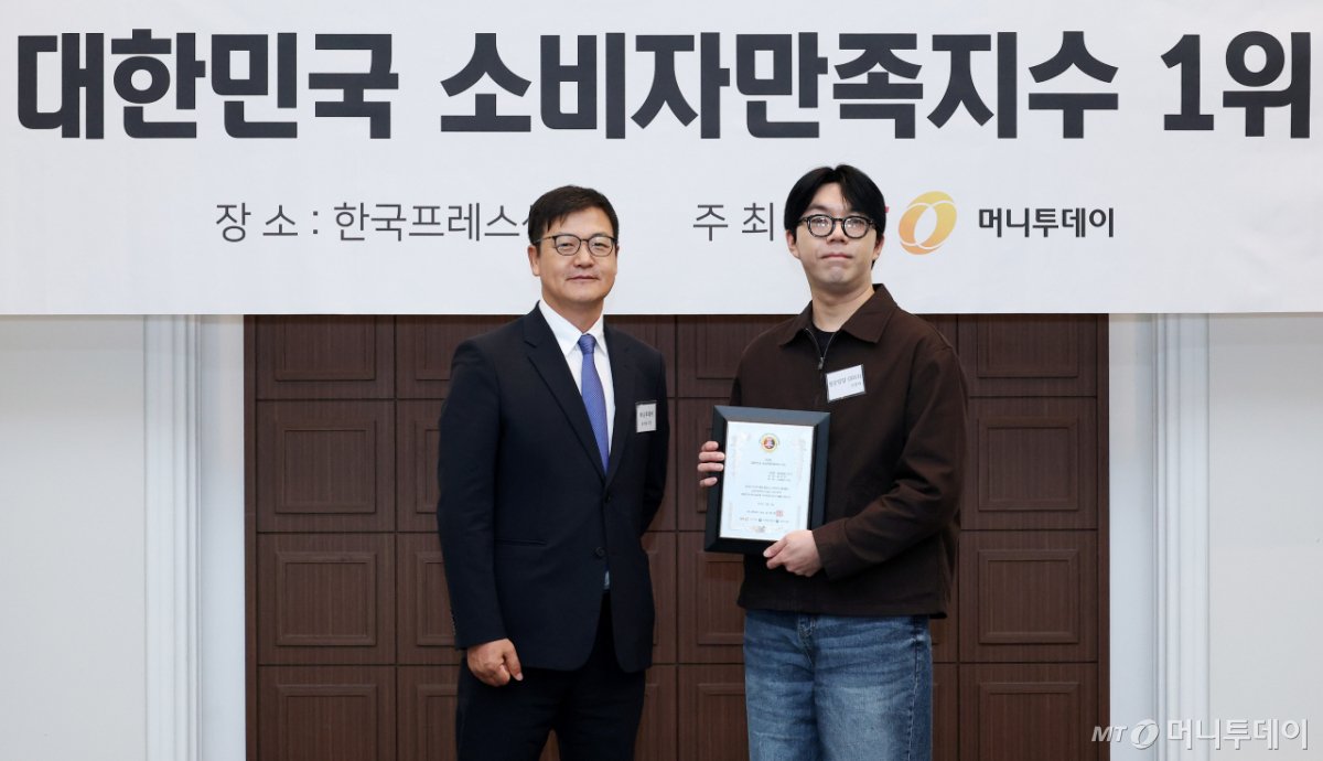 커피1011 관계자(오른쪽)가 '2026 대한민국 소비자만족지수1위' 수상 후 머니투데이 송기용 전무(왼쪽)와 기념 촬영을 하고 있다./사진=김창현 기자