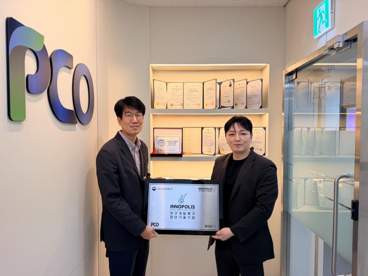 김대현 부산연구개발특구본부장(왼쪽)이 곽서준 PCO 대표에게 첨단기술기업 현판을 주고 함께 기념촬영을 하고 있다./사진제공=부산연구개발특구본부