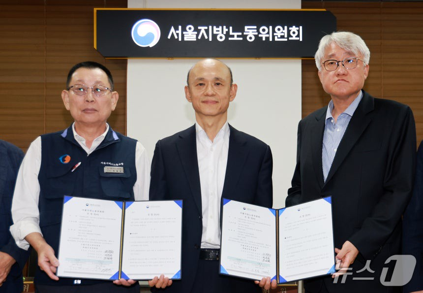 박점곤 서울시버스노동조합 위원장(왼쪽 첫번째), 권병희 서울지방노동위원회 조정위원장(가운데)과 김정환 서울시버스사업조합 이사장을 비롯한 참석자들이 16일 서울 영등포구 서울지방노동위원회에서 열린 특별조정위원회 2차 사후 조정 회의에서 서울 시내버스 노사 협상에 극적으로 합의한 뒤 기념촬영을 하고 있다./사진=뉴스1
