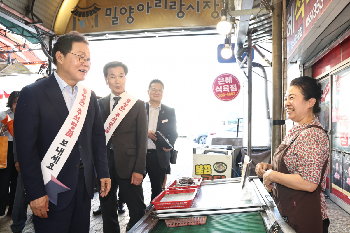 박완수 경남도지사(왼쪽)가 밀양아리랑시장을 찾아 물가를 점검하고 상인과 소통하고 있다./사진제공=경남도