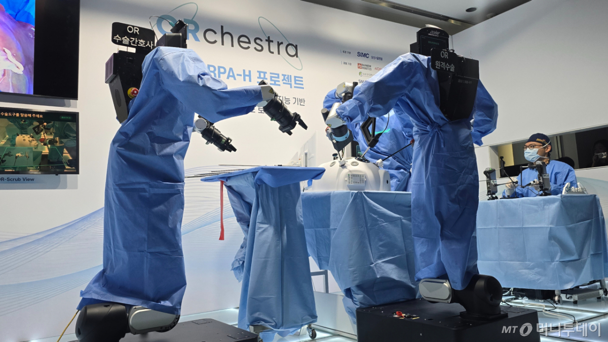  한 명의 집도의가 세 대의 휴머노이드 수술보조로봇을 조종하는 '원격 수술'(Teleoperated Surgery) 시연 장면. 직접 수술도구를 잡은 휴머노이드 수술보조로봇이 오남기 삼성서울병원 이식외과 교수가 모니터를 보며 동작하는 대로 행동을 모사하고 있다. /사진=홍효진 기자.