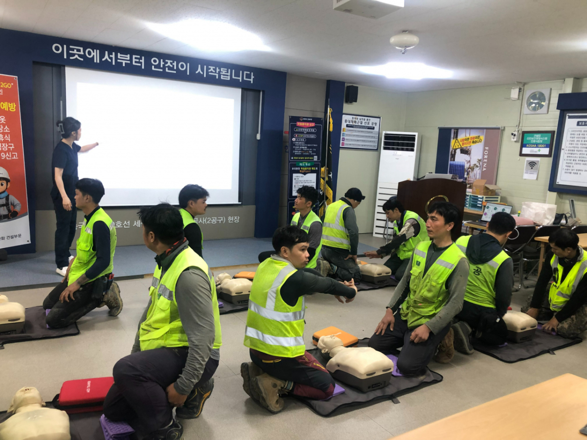 외국인 근로자들이 상황에 맞춰 자동심장충격기(AED)를 사용하고 있다. /사진제공=한화건설부문