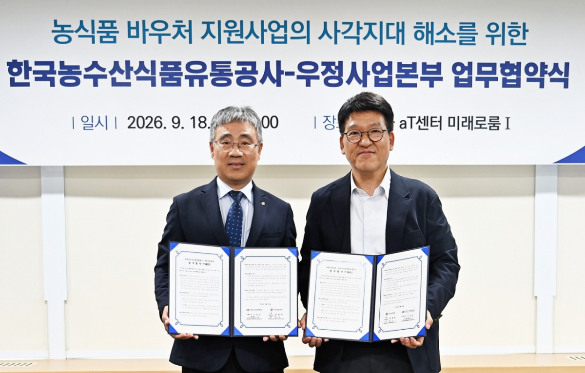 정철중 우정사업본부 우편사업단장(오른쪽)이 18일 서울 서초구 aT센터에서 기운도 한국농수산식품유통공사(aT) 유통이사와 농식품 바우처 지원을 위한 업무협약을 체결하고 있다./사진 제공=우정사업본부