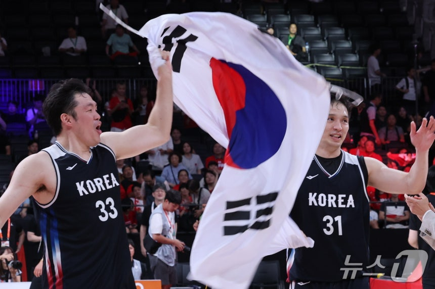 20일 일본 나고야 아이치 인터내셔널 아레나에서 열린 2026 아이치·나고야 아시안게임 남자농구 결승전 대한민국과 일본의 경기에서 금메달을 획득한 대한민국 이승현과 장재석이 태극기를 들고 기뻐하고 있다./나고야=뉴스1