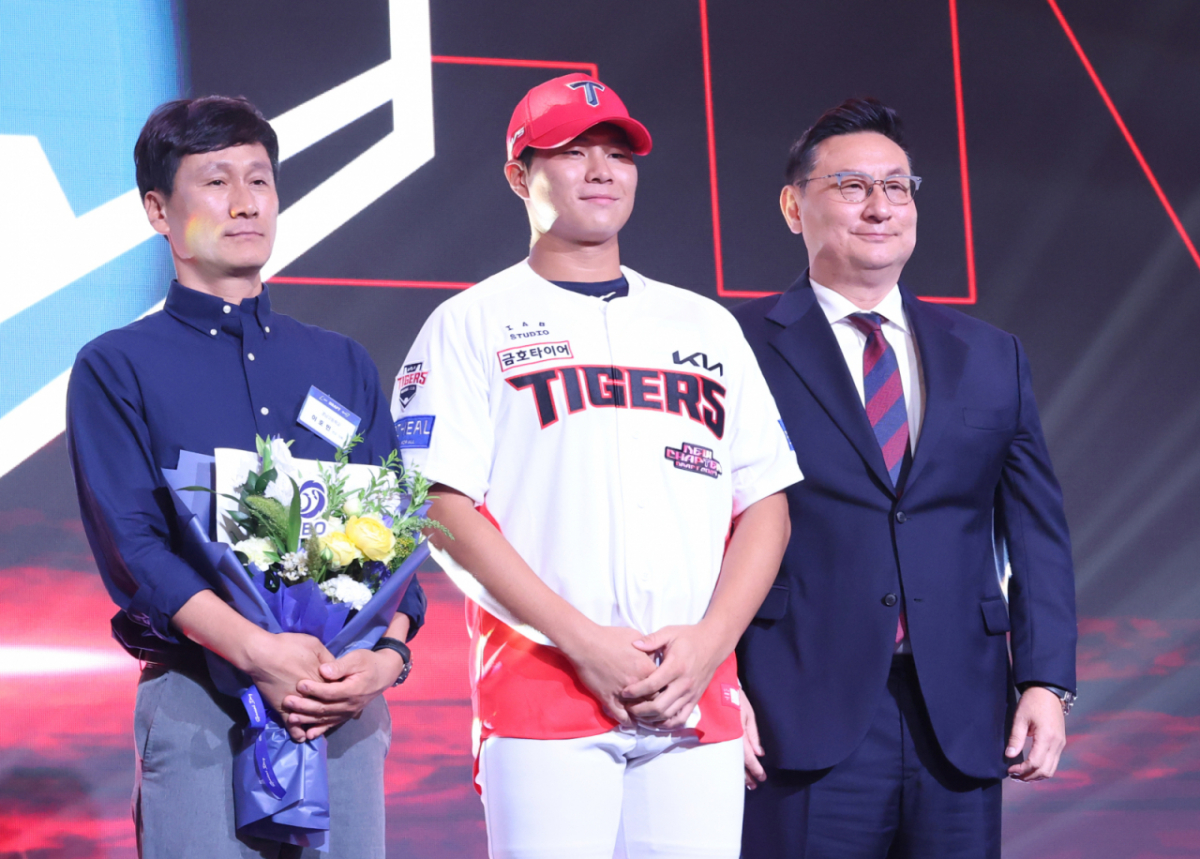 경남고 이호민(가운데)이 21일 서울 송파구 롯데호텔 월드 크리스탈볼룸에서 열린 '2027 KBO 신인 드래프트'에서 1라운드 3순위로 KIA 타이거즈의 지명을 받고 심재학 단장(오른쪽), 아버지와 함께 기념촬영을 하고 있다. /사진=김진경 대기자