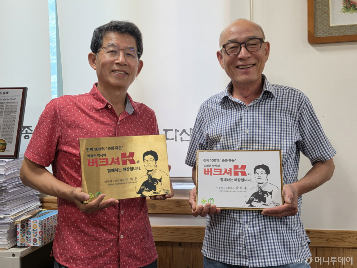 박화춘 다산육종 대표(왼쪽)와 오규석 상무가 버크셔K 관련 인증패를 들고 기념촬영을 하고 있다/사진=이수현 기자
