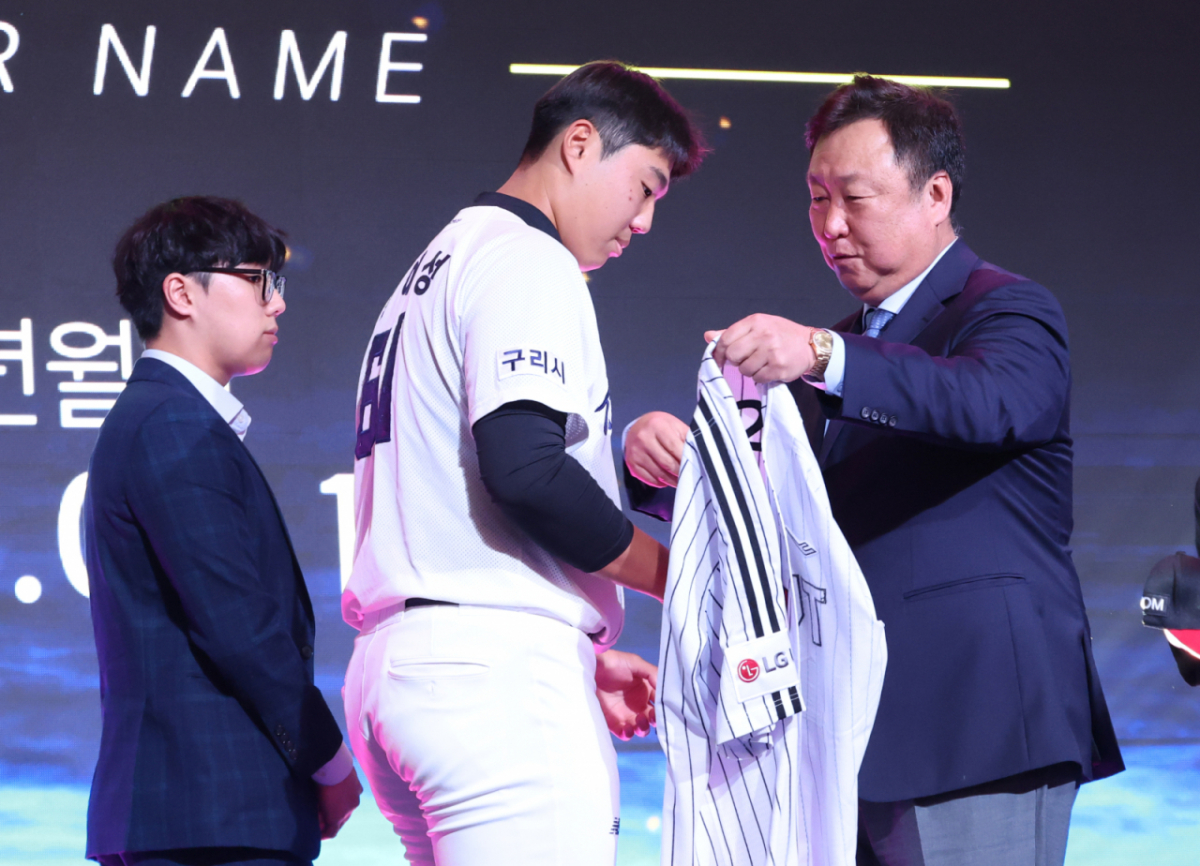 '2027 KBO 신인 드래프트'가 21일 서울 송파구 롯데호텔 월드 크리스탈볼룸에서 열렸다.  윤예성(인창고)이 전체 10순위로 LG에 지명된 후 차명석 단장의 도음으로 LG 유니폼을 입고 있다. /사진=김진경 대기자