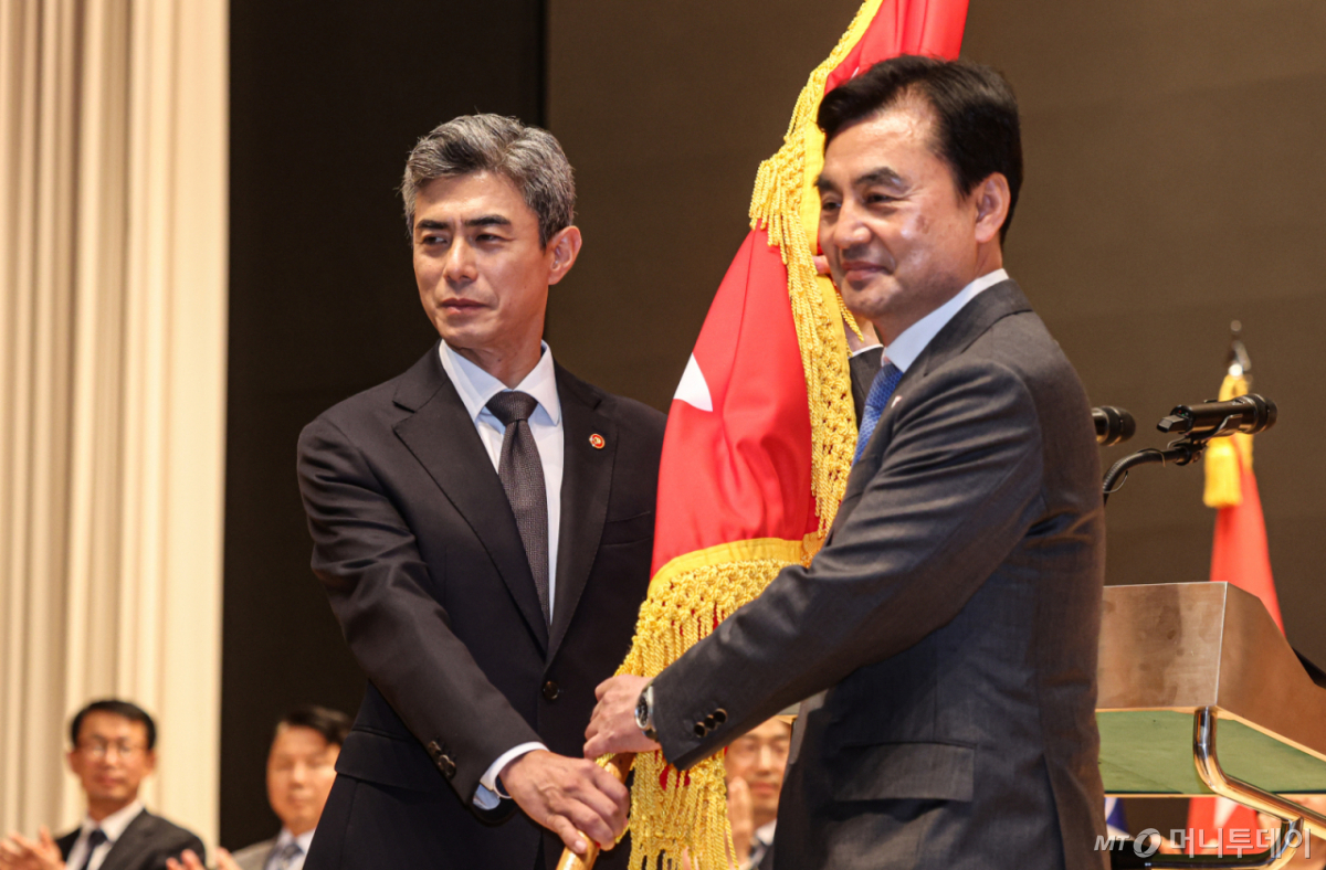 [서울=뉴시스] 김명년 기자 = 강신철 신임 국방부 장관이 22일 오후 서울 용산구 국방부에서 열린 제51대·52대 국방부 장관 이·취임식에서 안규백 전 장관에게 국방부기를 이양받고 있다.(공동취재) 2026.09.22. photo@newsis.com