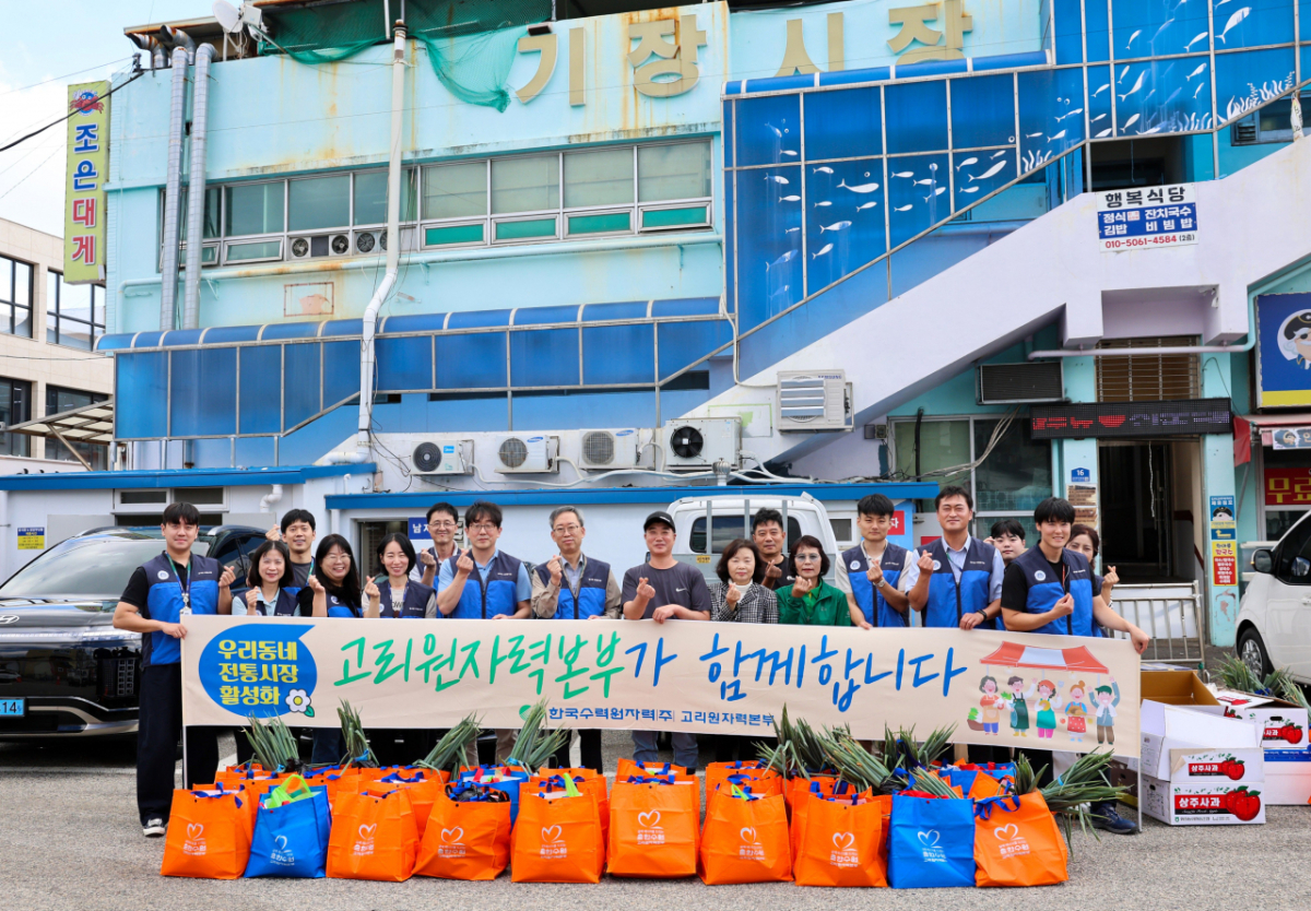 반병훈 고리원자력본부장(왼쪽에서 8번째)과 직원 등이 전통시장 활성화 캠페인을 하고 기념촬영을 하고 있다./사진제공=고리원자력본부