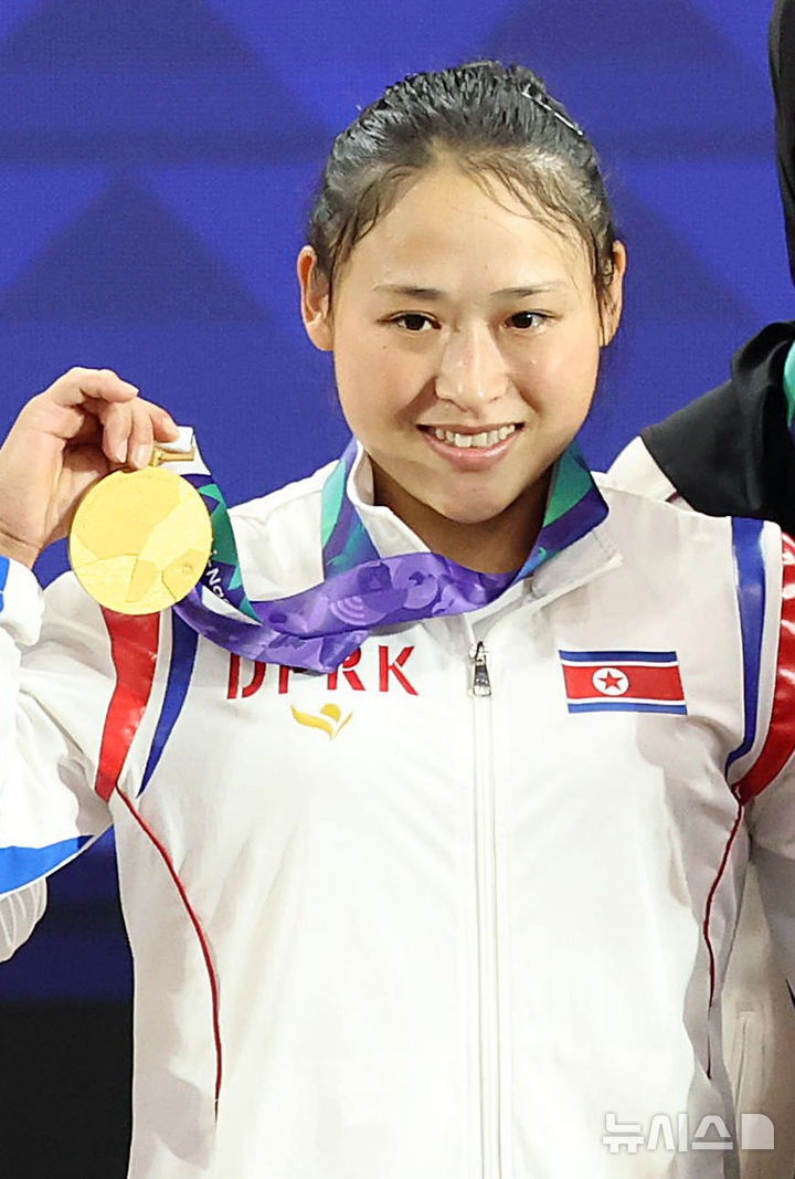 2026 아이치·나고야 아시안게임에서 첫 금메달을 따낸 북한이 공식 기자회견에서 한국 취재진의 '북한'이란 표현에 불쾌감을 나타내며 답변을 거부했다. 사진은 23일 일본 아이치현 나고야시 중소기업진흥회관에서 열린 2026 아이치·나고야 아시안게임 역도 여자 49kg급 시상식에서 금메달을 획득한 북한 리성금이 인사를 하고 있는 모습./나고야(일본)=뉴시스