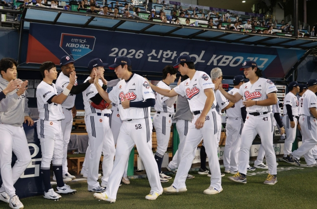 2026 아이치 나고야 아시안게임에서 금메달을 따고 돌아온 선수들이 29일 NC 다이노스와 홈경기를 앞두고 축하 행사를 마친 뒤 동료들과 하이파이브를 하고 있다. /사진=두산 베어스 제공
