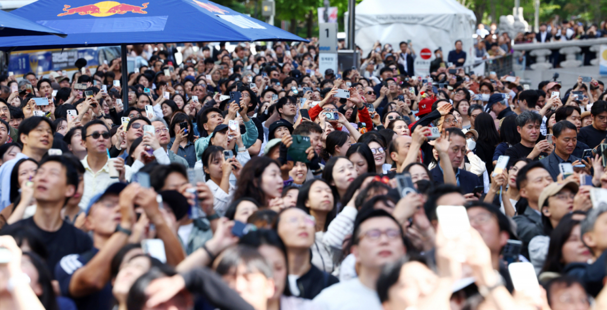 1일 서울 청계광장에서 시민들이 세종대로 상공에 펼쳐지는 '슬랙라인' 세계챔피언 얀 루스의 퍼포먼스를 지켜보고 있다. 세계적인 슬랙라인 선수 루스(위 사진)는 이날 서울 종로구 광화문네거리에서 열린 '레드불 서울 줄타기' 행사에서 고공 슬랙라인에 도전했다.   /사진=뉴스1