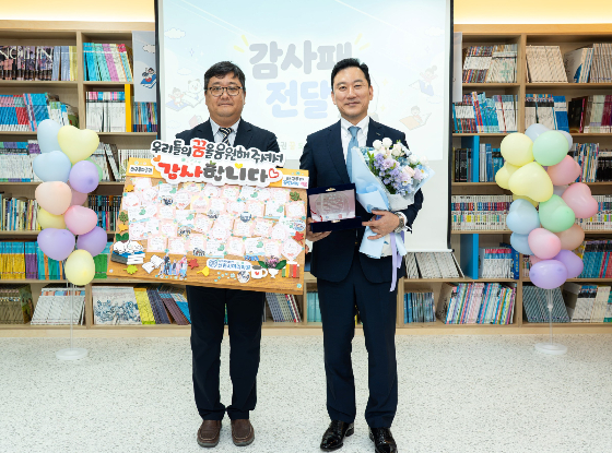 김성환 한국투자증권 사장(오른쪽)이 지난 1일 용인 선한사마리아원에서 열린 '꿈 도서관' 개관식에서 송한철 원장 및 원아들이 건넨 감사패를 들고 기념사진을 촬영하고 있다./사진=한국투자증권