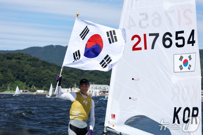 하지민이 2일 일본 아이치현 가마고리 가이요 요트 항구에서 열린 2026 아이치·나고야 아시안게임 요트 남자 딩기 결승 레이스에서 1위를 차지하고 태극기를 흔들고 있다. /사진=뉴스1