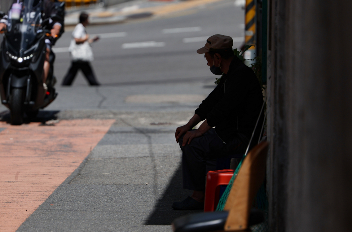 A resident sits in the shade to cool off at a single-room apartment village in Dongaji-dong, Yongsan-gu, Seoul, on July 29. /Photo=NEWSIS
