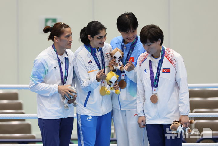 일본 아이치현 니시오시 니시오 체육관에서 열린 2026 아이치·나고야 아시안게임 복싱 여자 65kg 시상식에서 동메달을 획득한 북한 황효순(오른쪽)이 다른 메달 수상자들과의 손하트 기념촬영을 거부하고 자리를 이동하고 있다. /사진=뉴시스