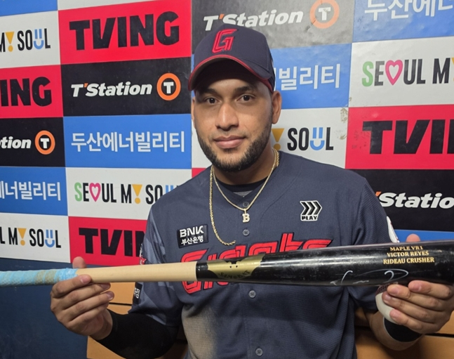 210번째 안타(홈런) 공을 습득한 팬에게 전달할 사인 배트와 함께 기념 촬영을 하는 레이예스. /사진=박수진 기자