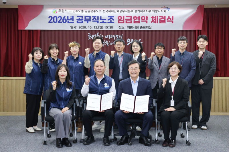 김성제 의왕시장(앞줄 가운데 오른쪽)과 이태겸 공공운수노조 전국자치단체공무직본부 경기지역지부 의왕시지회장이 입금협약을 체결하고 기념촬영을 하고 있다./사진제공=의왕시