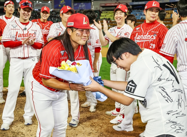 SSG 랜더스 한두솔(왼쪽)이 17일 인천 SSG랜더스필드에서 '2026 랜더스페셜 매치 - 최광야구 1429'에서 맹활약을 펼친 뒤 최우수상을 수상한 뒤 팬에게 꽃다발을 건네 받고 있다. /사진=SSG 랜더스 제공