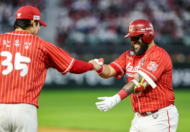 SSG 랜더스 페드로 아빌라(오른쪽)가 17일 인천 SSG랜더스필드에서 '2026 랜더스페셜 매치 - 최광야구 1429'에서 안타를 날리고 한유섬과 악수를 나누고 있다. /사진=SSG 랜더스 제공