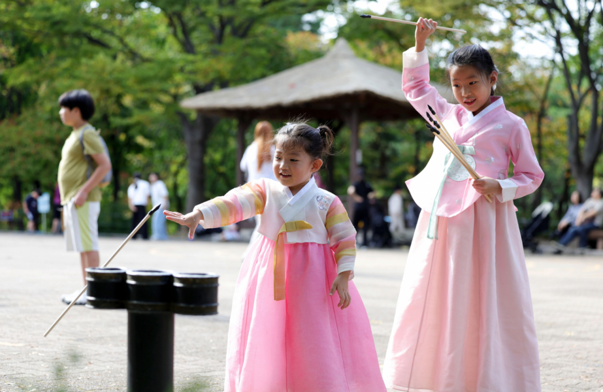 지난달 26일 서울 중구 남산골한옥마을에서 열린 2026 남산골 추석축제 '남산달빛마당'을 찾은 어린이들이 한복을 입고 투호 던지기를 즐기고 있다. / 사진 = 뉴시스