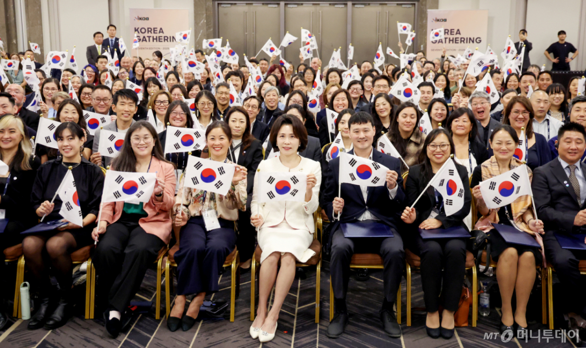 [서울=뉴시스] 조성봉 기자 = 김혜경 여사가 19일 서울 강님구 코엑스에서 열린 세계한인입양인협회(IKAA) 개더링 한국대회 개회식에서 토미 겐첼(오른쪽 네번째) IKAA 회장을 비롯한 참석자들과 태극기를 들고 기념 촬영을 하고 있다.2026.10.19. suncho21@newsis.com /사진=조성봉